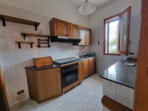 una cucina con mobili in legno e un forno a piano cottura di CASA VIANNA a Magliano Altre 8 foto