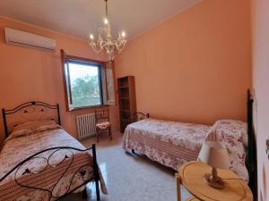 una camera da letto con due letti e un lampadario di CASA VIANNA a Magliano