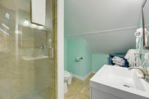 uma casa de banho com um chuveiro, um lavatório e um WC. em Traveler's Palm by Brightwild em Key West
