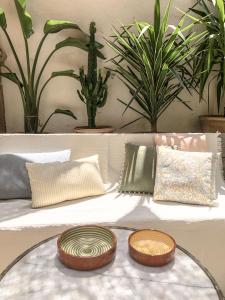 two plates on a table with pillows on a couch at Maison Olea in Marseille +18 photos