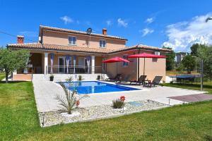 a villa with a swimming pool in front of a house at Ferienhaus mit Privatpool für 8 Personen ca 130 qm in Divšići, Istrien Südküste von Istrien in Divšići