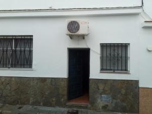 un edificio blanco con una puerta y un aro de baloncesto en Apartamento araceli en Chipiona