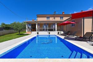 a swimming pool in front of a house at Ferienhaus mit Privatpool für 8 Personen ca 130 qm in Divšići, Istrien Südküste von Istrien in Divšići