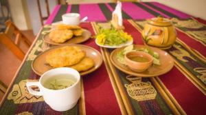 una mesa con platos de comida en una mesa en Quinuawasi House en Ocosuyo