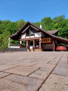 une maison avec une voiture garée devant elle dans l'établissement CASA DIN PADURE, à Brad