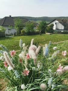 un campo de flores en un patio con una casa en Sabrina's Ferienwohnung, en Hammelburg