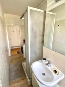 een badkamer met een wastafel en een spiegel bij Komplette Wohnung nahe am See in Prenzlau