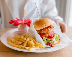 a plate with a chicken sandwich and french fries at Alaise De Bale Ishigaki in Ishigaki Island