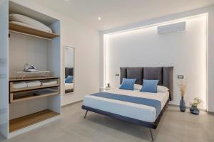 a bedroom with a large bed with blue pillows at Case Vacanza Loria in Castelluzzo