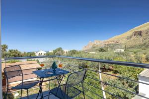 a balcony with a table and chairs and mountains at Case Vacanza Loria in Castelluzzo