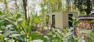 een klein huis in een tuin met bomen bij Logies Prinsewyk De Knipe/Oranjewoud 