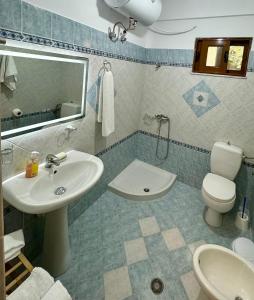 a bathroom with a sink and a toilet and a mirror at SHEMO Apartments in Sarandë