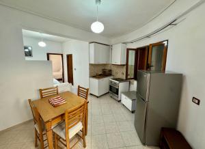 a kitchen with a table and a refrigerator at SHEMO Apartments in Sarandë +16 photos