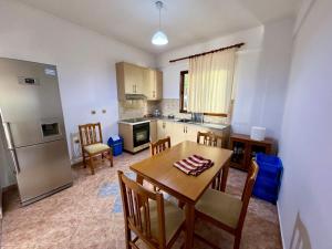 a kitchen and dining room with a table and chairs at SHEMO Apartments in Sarandë