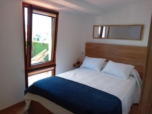 Un dormitorio con una cama grande y una ventana en A PINTEGA DAS DUNAS en Ribeira