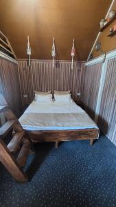 ein Schlafzimmer mit einem großen Bett mit einem Holzrahmen in der Unterkunft Casa Petra in Sărata-Monteoru