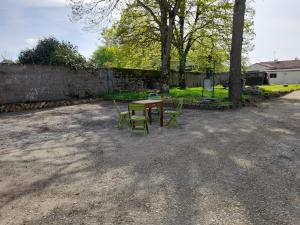 un tavolo e sedie seduti in un cortile di RELAI DU CHATEAU APPARTHOTEL a La Tourlandry