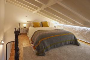 ein Schlafzimmer mit einem Bett mit gelben Kissen in der Unterkunft Maison214 in Vila Nova de Gaia