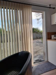 una sala de estar con una puerta corredera de cristal con persianas en RELAI DU CHATEAU APPARTHOTEL, en La Tourlandry