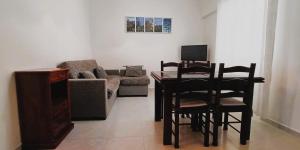 - un salon avec une table, des chaises et un canapé dans l'établissement AL Bela Vida, à Tavira