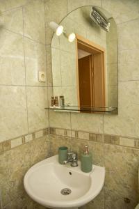 ein Bad mit einem Waschbecken, einem Spiegel und einem Spiegel in der Unterkunft Villa Marto Old Town Ohrid in Ohrid