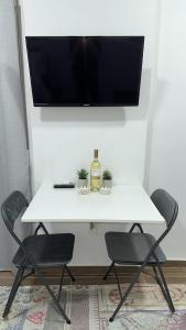 a white table with a bottle of wine and two chairs at Paul’s Houses in Drama