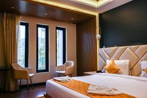 Beyond Blu في ميناء بلير: غرفة نوم بسرير كبير مع كرسيين ونوافذ