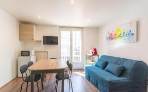 a living room with a blue couch and a table at Appartement T3 gare de Chambéry centre ville in Chambéry