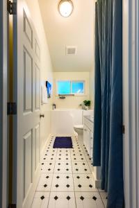a bathroom with a white door and a black and white tile floor at Blue House - country living close to everything in Eugene