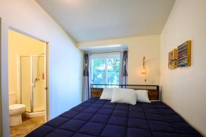 um quarto com uma cama azul e uma janela em Blue House - country living close to everything em Eugene