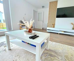 a white coffee table in a living room with a tv at Family Home with Free Parking in Newton Mearns