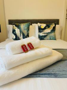 dwa ręczniki na łóżku z dwoma poduszkami w obiekcie Robinhuts Stays - 3 Bed property Perfect for contractors and families w mieście Hull