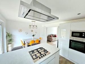 a kitchen with a stove top oven next to a living room at Family Home with Free Parking in Newton Mearns