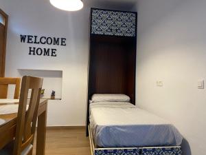 Habitación con 2 camas y un cartel de bienvenida. en La Pequeña Morada, en Arcos de la Frontera