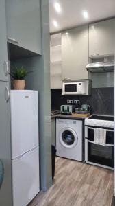 cocina con nevera blanca y lavavajillas en Entire, lovely apartment with a bath tub, en Glasgow