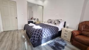 1 dormitorio con 1 cama con espejo y silla en Entire, lovely apartment with a bath tub, en Glasgow