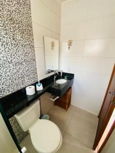 a bathroom with a toilet and a sink at Apartamento em Ubatuba - Condomínio Ville II - 300 metros da Praia do Sapê - Maranduba in Ubatuba