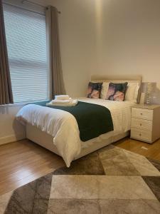 a bedroom with a large bed with a window at Robinhuts Stays - 3 Bed property Perfect for contractors and families in Hull