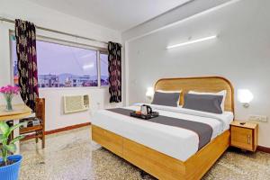 ein Schlafzimmer mit einem großen Bett und einem Fenster in der Unterkunft All Season stayz in Haridwar