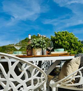 - une table blanche avec des verres à vin sur le balcon dans l'établissement Penthouse Burgblick mit Dachterrasse, à Staufen-en-Brisgau