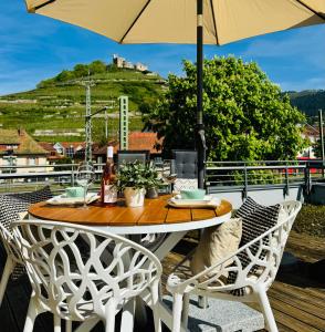 a table and chairs with an umbrella on a deck at Penthouse Burgblick mit Dachterrasse in Staufen im Breisgau