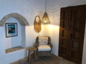 una camera con sedia, tavolo e lampada di Casa Esmeralda a Vejer de la Frontera