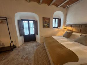 una camera con un grande letto e due finestre di Casa Esmeralda a Vejer de la Frontera