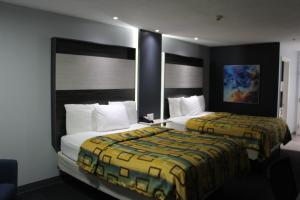 Dos camas en una habitación de hotel con dos en Douglas Inn & Suites en Cleveland