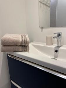Un baño blanco con lavabo y espejo. en Appartement T3 gare de Chambéry centre ville, en Chambéry 39 fotos más