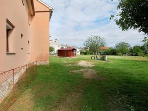 einen Hof mit einem Zaun neben einem Gebäude in der Unterkunft Studio für 5 Personen ca 50 qm in Fažana, Istrien Istrische Riviera - b60913 in Valbandon
