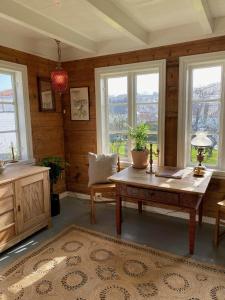 sala de estar con mesa de madera y ventanas en Elins gjestehus, en Egersund