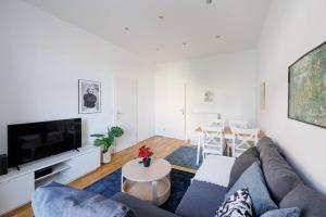 - un salon avec un canapé et une télévision dans l'établissement Modern Apartment near City Center - 2BR, Netflix, à Vienne