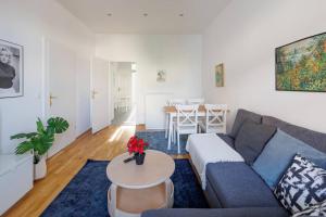 - un salon avec un canapé bleu et une table dans l'établissement Modern Apartment near City Center - 2BR, Netflix, à Vienne