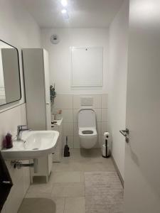 a white bathroom with a toilet and a sink at KG Apartment in Hannover